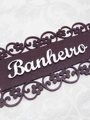Placa marrom trabalhada arabescos para porta de banheiro