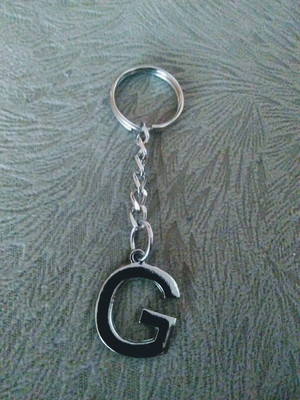 Chaveiro prateado letra g.