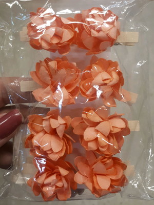 8 mini pregadores de madeira com flores de papel.