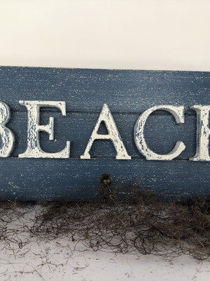Placa decorativa em madeira envelhecida com a palavra beach