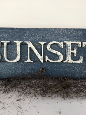 Placa decorativa em madeira envelhecida com a palavra sunset