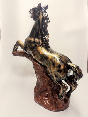 Cavalo em gesso empinado no tronco