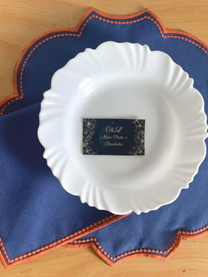 Sousplat azul com linhas laranja e guardanapo
