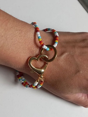 Pulseira dourada com miçangas e fecho coração
