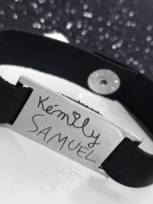 Pulseira em couro com placa em aço inox com escrita
