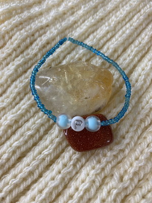 Pulseira de miçangas azul com detalhe letra personalizada