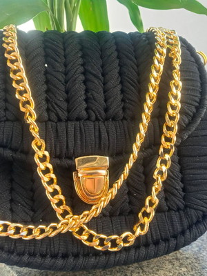 Bolsa preta feminina com alças douradas e fecho