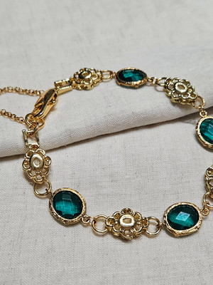 Pulseira dourada com cristais verdes
