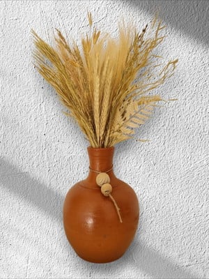 Vaso de barro com flores desidratadas