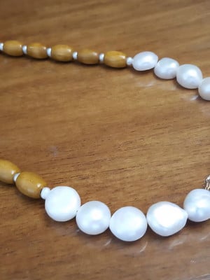 Colar de pérolas e madeiras naturais