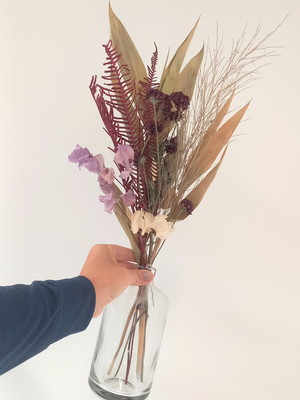 Arranjo flores desidratadas secas em garrafa de vidro