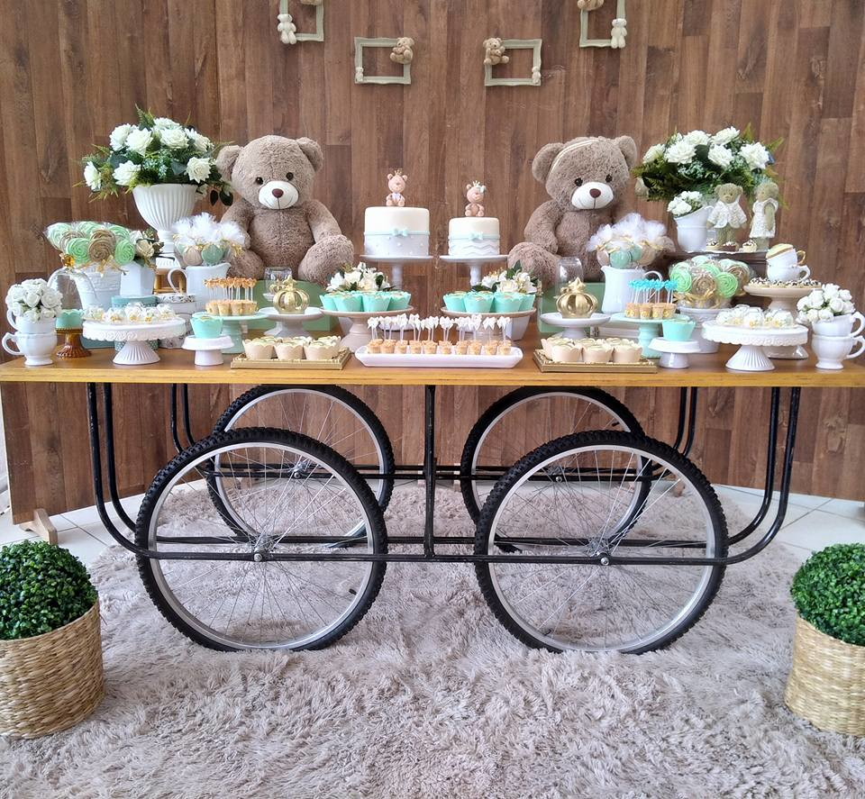Decoração de chá de bebê gêmeos com painel rústico, mesa móvel, dois bolo e doces em dobro, além de ursinhos e jarros com plantas brancas