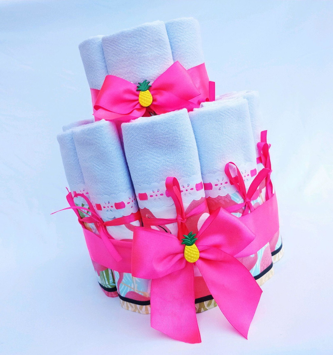Lembrancinha chá de cozinha bolo de panos de pratos tema Havaí. Com bordados e fitas rosa e detalhe de abacaxi. Disponível no lembrancinhasdefesta.com.br/bolosfake